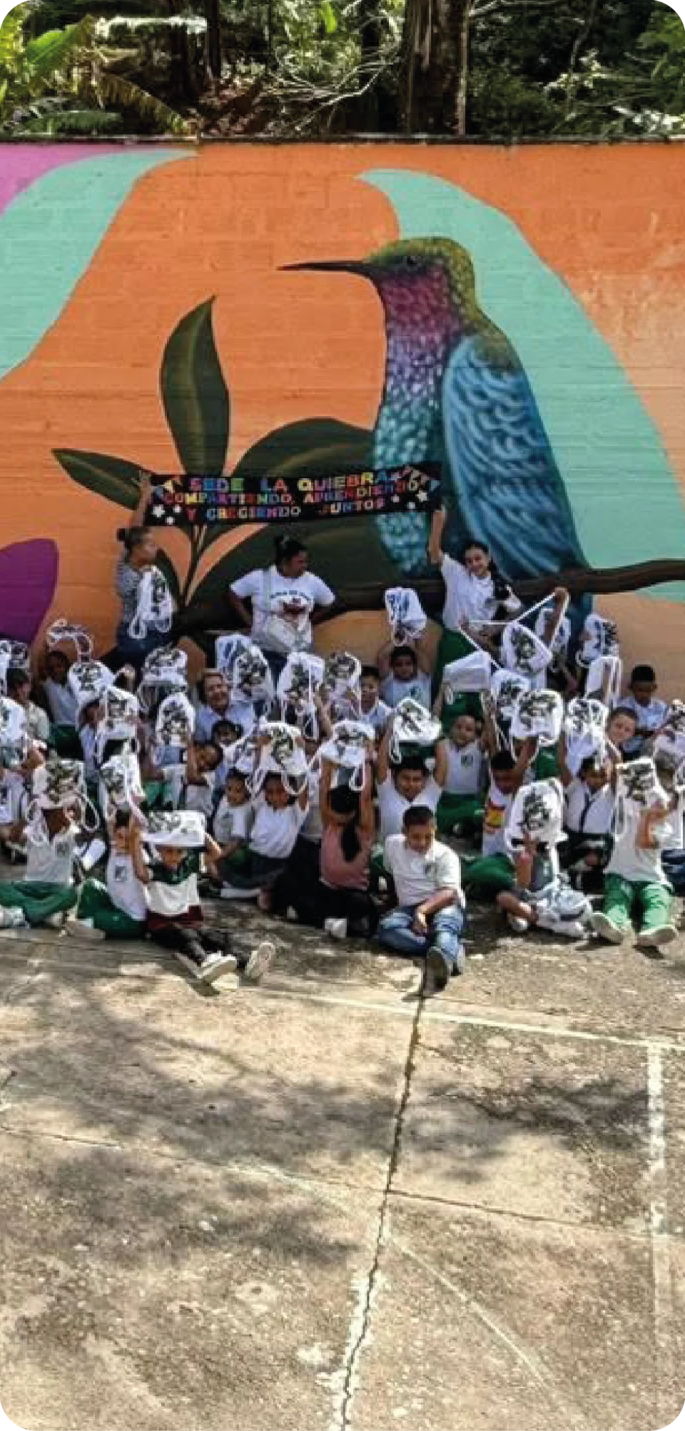 Estudiantes reunidos frente a un mural ambiental